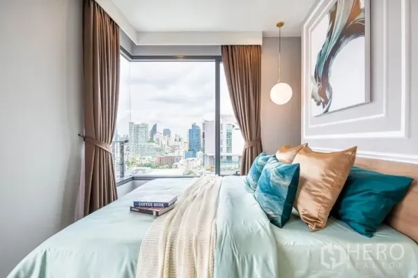 Condominium for rent or sale in Watthana, Bangkok - Corner bedroom with large windows, pendant light and a city skyline view.