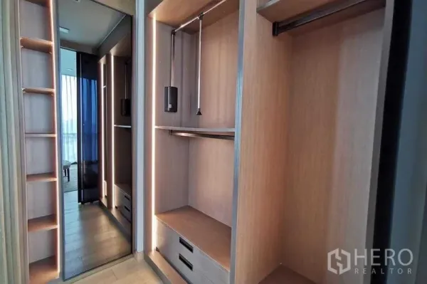 Condominium for rent or sale in Watthana, Bangkok - Built-in walk-in closet with open shelving, hanging rails and a full-height mirror.