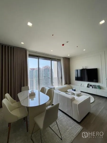 Condominium for rent in Bang Kho Laem, Bangkok - Living and dining area with sofa set, TV wall, and floor-to-ceiling windows.