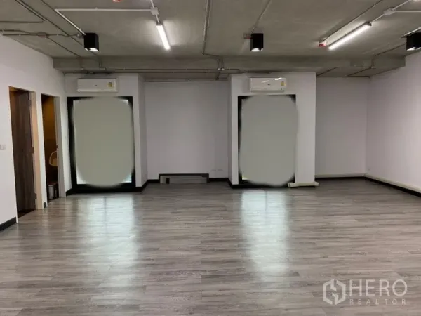 办公空间 出租 - 开放式办公室，灰色木纹地板、裸露混凝土顶与LED灯，两扇大窗配壁挂空调。
