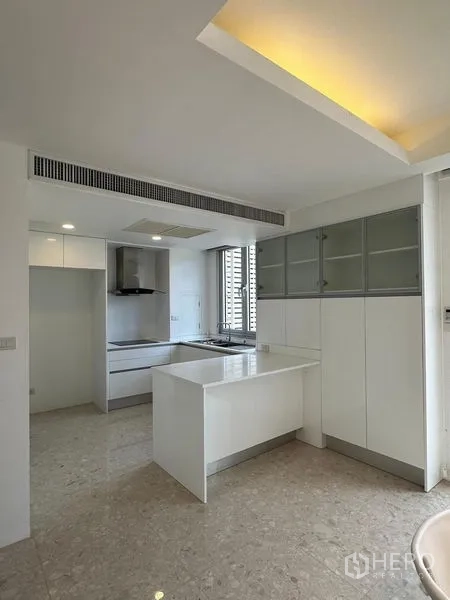 Townhouse for sale in Yan Nawa, Bangkok - Bright kitchen with ample cabinetry, a small island counter and recessed ceiling lights.