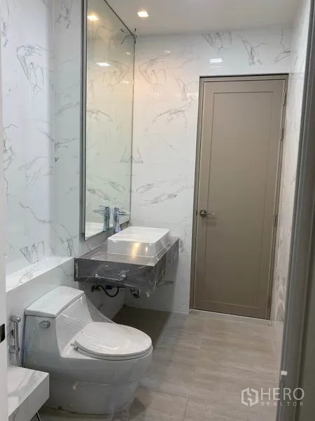 Townhouse for rent in Yan Nawa, Bangkok - Modern bathroom with large mirror, vanity and toilet.