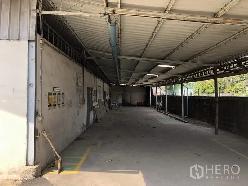 货栈 出租在Khlong Luang, Pathum Thani - 建筑侧边的长廊带顶，可装卸或停车，靠围墙。