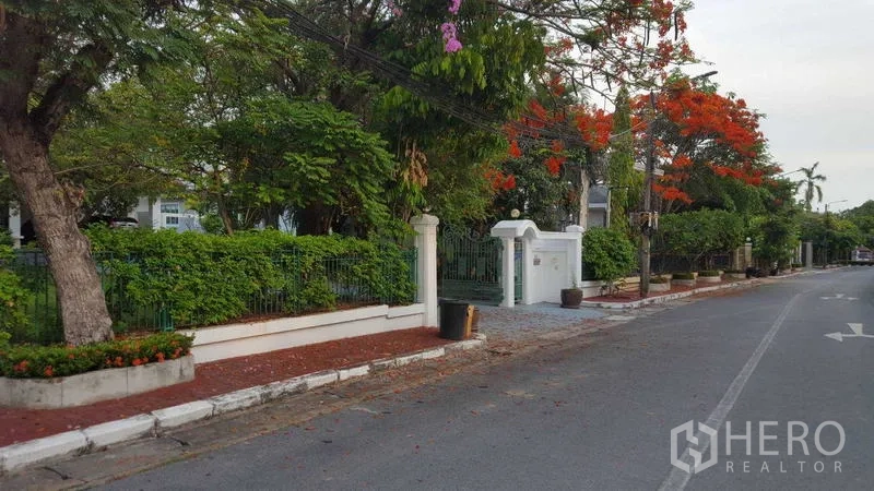 独立式住宅 出租在Bang Phli, Samut Prakan - 安静街道上的房屋前围墙与绿色栅栏。