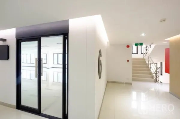 Office Space for rent in Chatuchak, Bangkok - Bright corridor with glass entry door marked 6 and stairs beside it.