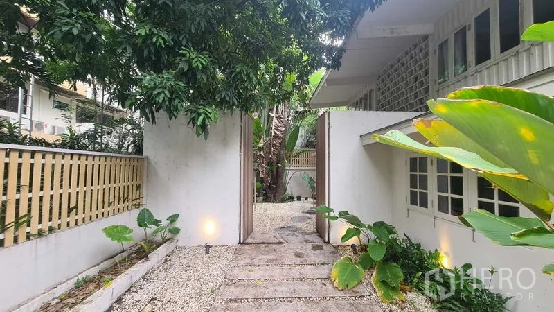Detached House for rent in Watthana, Bangkok - Garden entry gate with stone path and tropical plants.