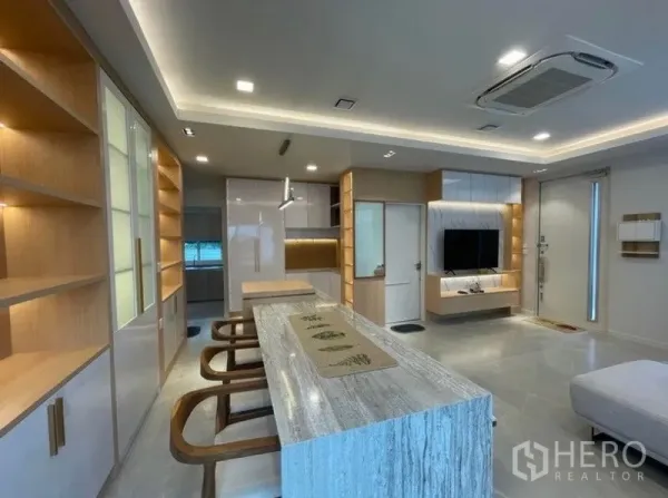 独立式住宅 出租在Prawet, Bangkok - 现代厨房与长岛台，收纳充足并配有暖色灯带。