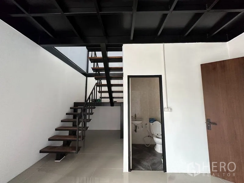 Warehouse for rent or sale in Lam Luk Ka, Pathum Thani - Mezzanine staircase and ground-floor restroom inside the warehouse office area.