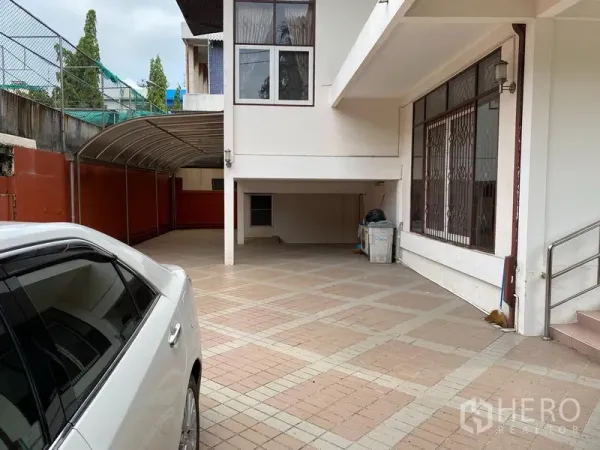 独立式住宅 出租在Khlong Toei, Bangkok - 两层独栋别墅的铺砖车道与带顶车棚，宽敞的一层露台。