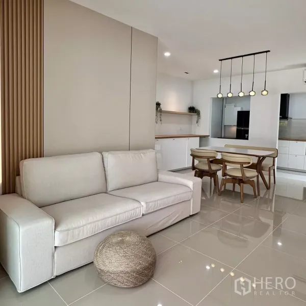 联排别墅 出租在Bang Phli, Samut Prakan - 开放式客餐厅，米色沙发与餐桌，特色背景墙。