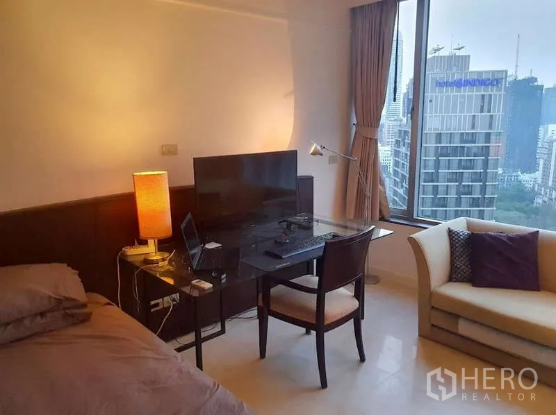 Condominium for sale in Pathum Wan, Bangkok - Bedroom study area with glass desk by window overlooking the skyline