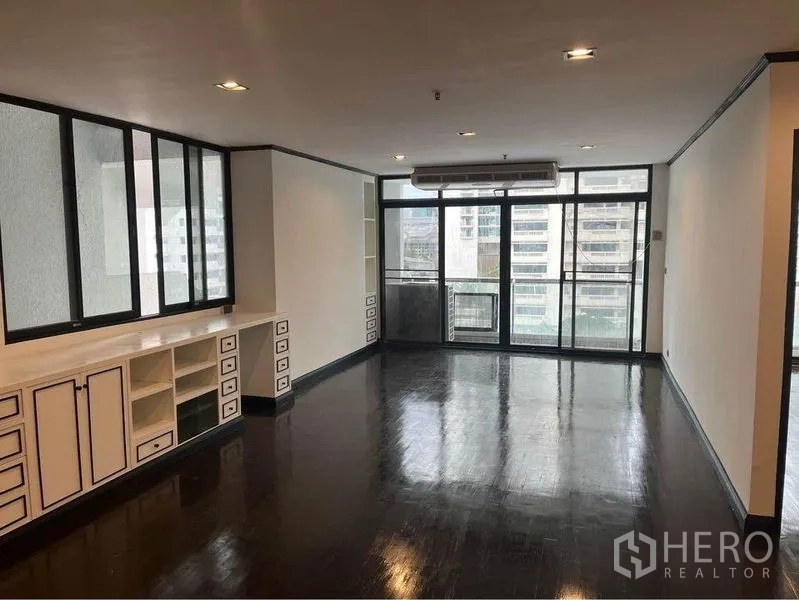 Condominium for rent or sale in Watthana, Bangkok - Living area facing large glass doors to balcony with city view.