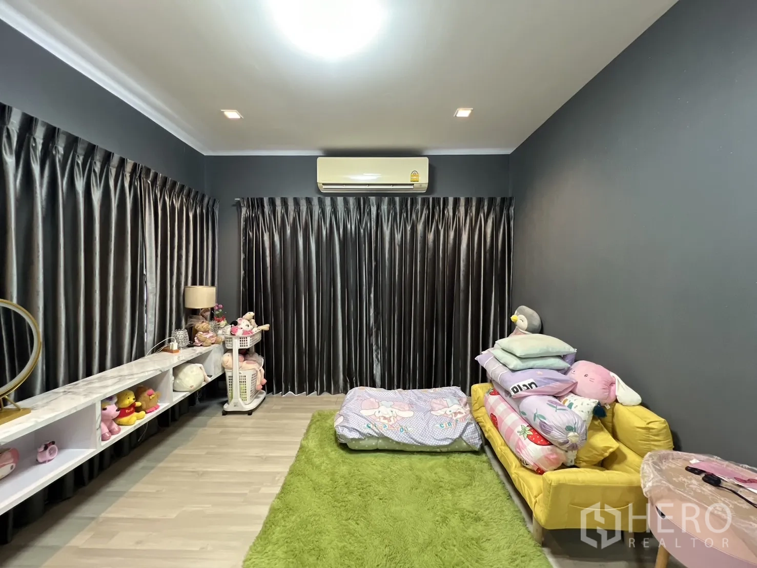 独立式住宅 出租或出售在Lat Krabang, Bangkok - 主卧，深色强调墙，黄色沙发与绿色地毯