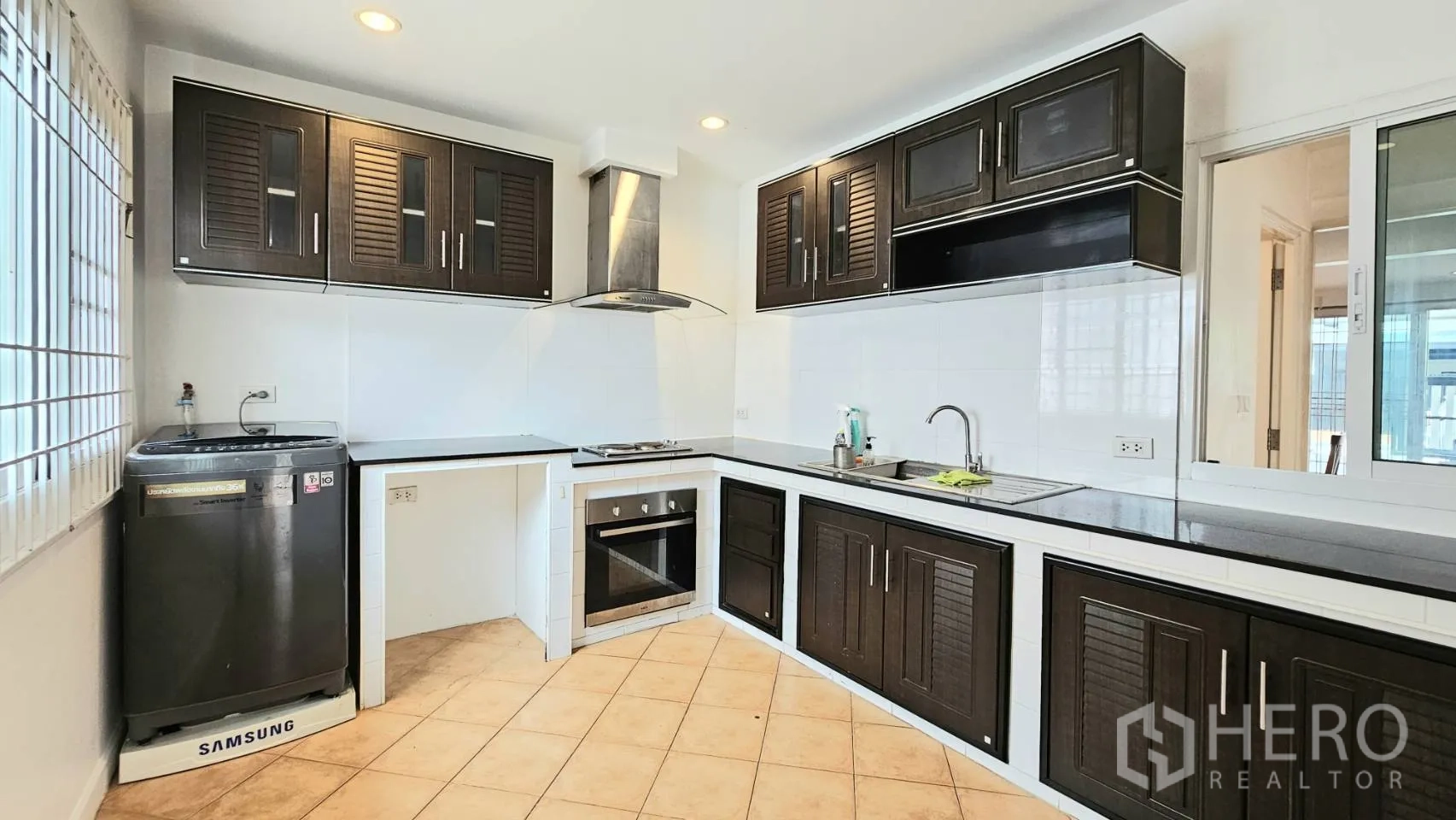 独栋房屋 for rent in Saphan Sung, Bangkok - 宽敞L型厨房，深色橱柜、双水槽与充足台面。