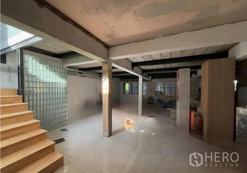 办公空间 出租在Khlong Toei, Bangkok - 开放式办公室内景，裸露梁柱、玻璃砖隔断、亮面地砖与木楼梯，自然采光充足。