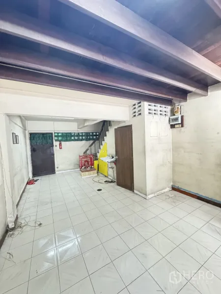 店屋 出租在Watthana, Bangkok - 一层后场带水槽、储物间、楼梯与外露梁架。