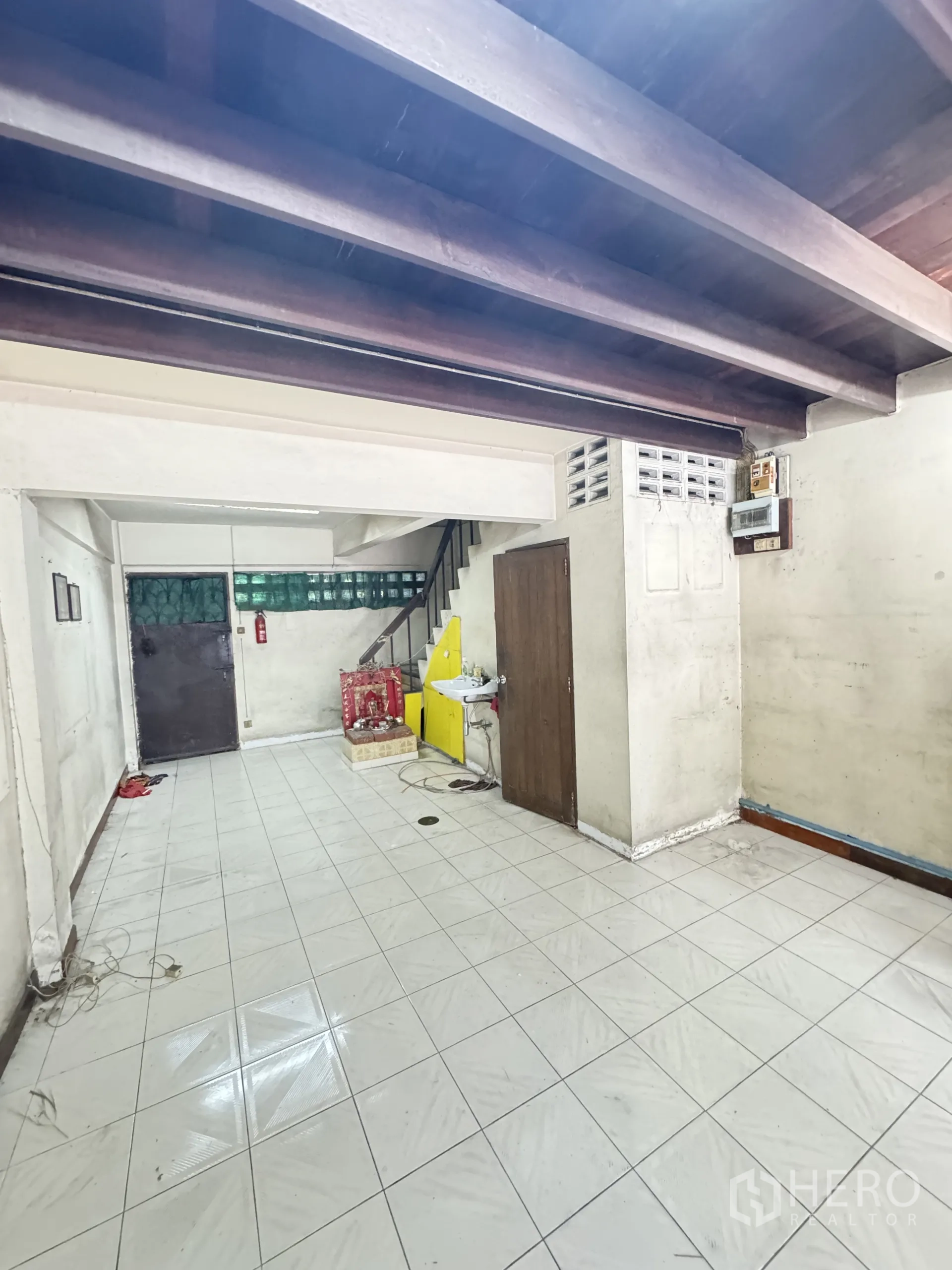 店屋 出租在Watthana, Bangkok - 一层后场带水槽、储物间、楼梯与外露梁架。