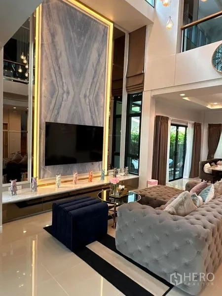 บ้าน ให้เช่าในPrawet, Bangkok - ห้องนั่งเล่นเพดานสูงสองชั้น ผนังทีวีหินอ่อน โซฟาบุผ้าทัฟต์ และหน้าต่างบานใหญ่