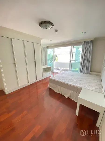 房间 出租在Watthana, Bangkok - 主卧实木地板，白色内置衣柜，直通阳台。