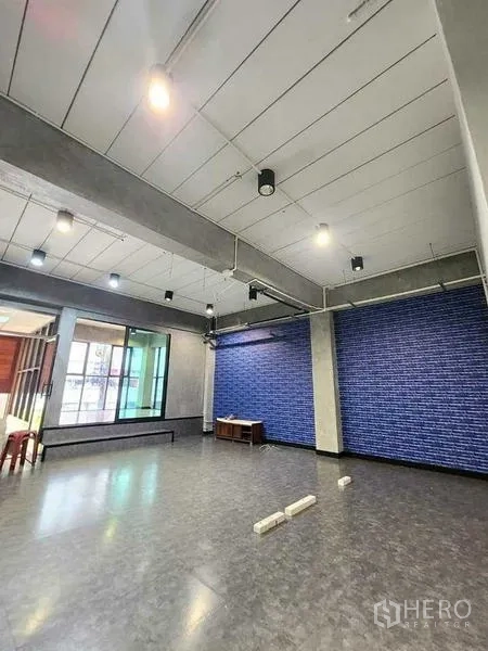 办公空间 出租或出售在Bueng Kum, Bangkok - 多功能大空间，灰色乙烯基地面、蓝色强调墙、大窗与轨道灯。