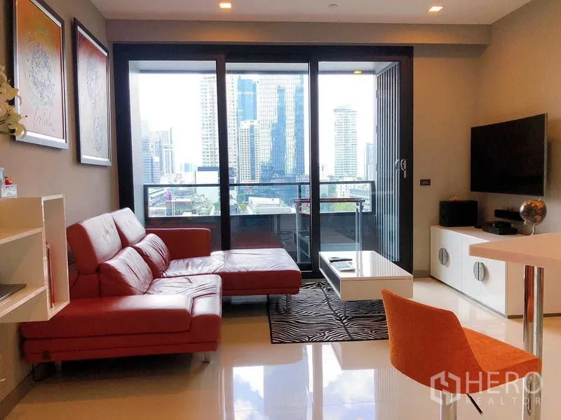 Condominium for rent in Bang Rak, Bangkok - Living area opening to a balcony with panoramic skyline backdrop.