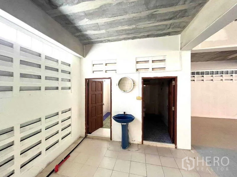 Warehouse for rent in Bang Phli, Samut Prakan - Restroom area with sink and two separate doors within the warehouse.