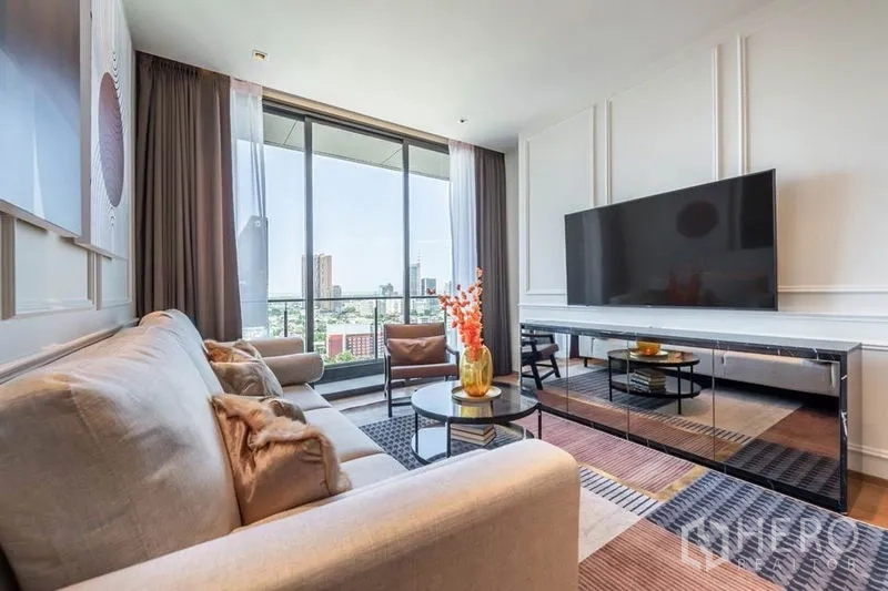 Condominium for rent in Khlong Toei, Bangkok - Spacious lounge with floor-to-ceiling windows, TV console and skyline beyond.