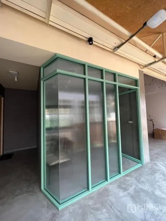 Retail Space for rent in Watthana, Bangkok - Industrial-style retail unit with mint-green framed ribbed-glass corner partition and concrete floor.