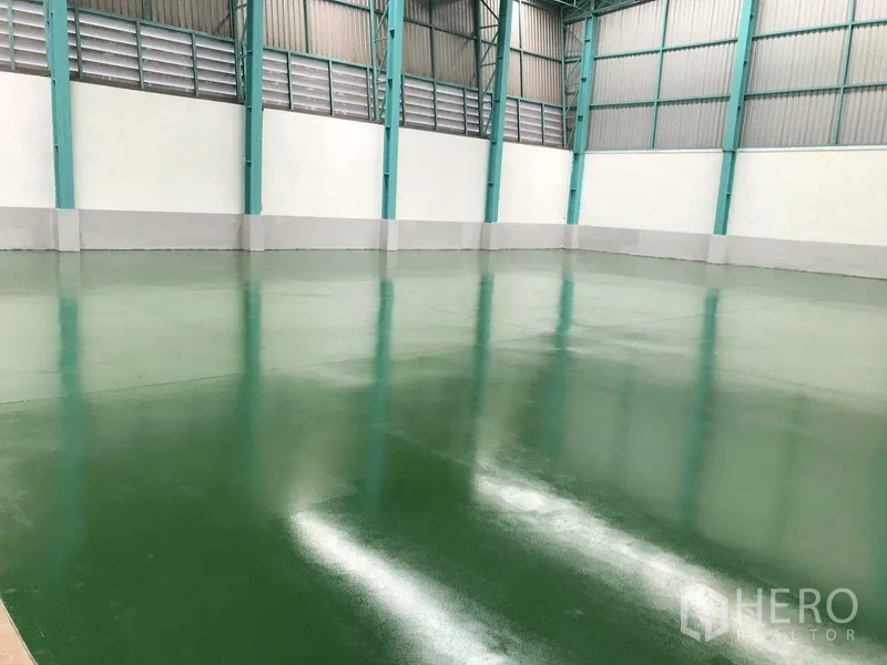 Factory for rent in Samut Prakan - Polished green epoxy factory floor with ventilated side walls and steel columns.