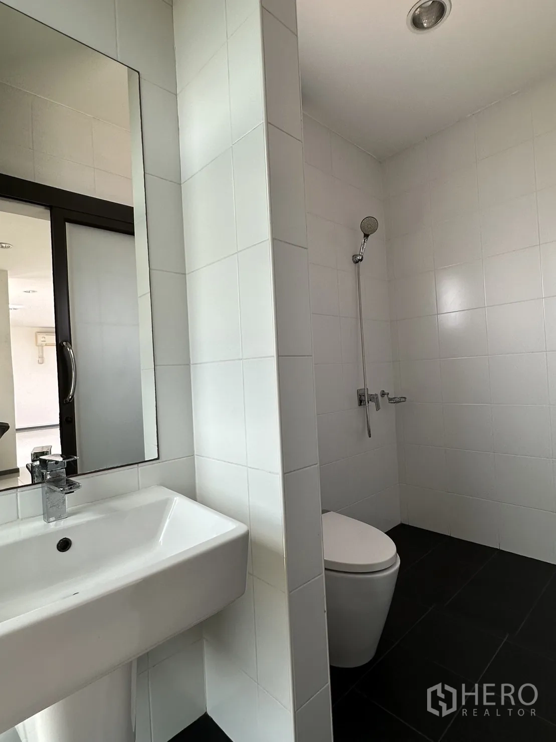 Factory for rent or sale in Pathum Thani - Tiled bathroom with shower, toilet and vanity.