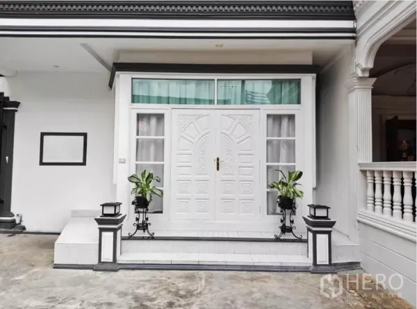 独立式住宅 出租在Yan Nawa, Bangkok - 房屋正门，雕花白色双开门，台阶两侧摆放绿植。
