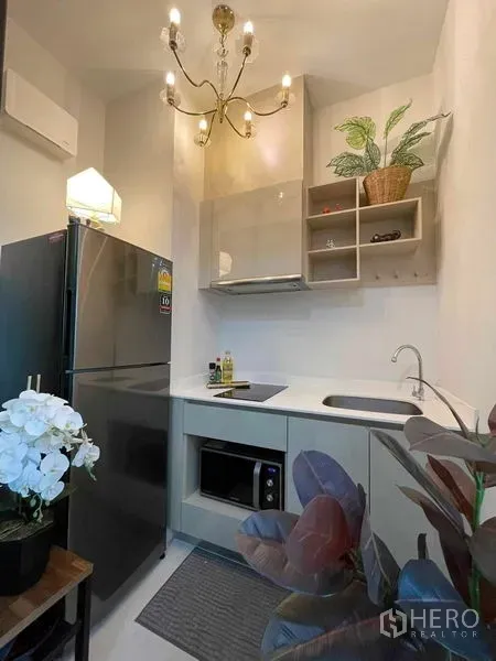 公寓 出售在Huai Khwang, Bangkok - 紧凑厨房，吊灯照明，不锈钢冰箱，内置橱柜，水槽与微波炉。