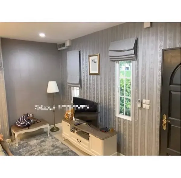 Townhouse for rent in Bang Kapi, Bangkok - Cozy living area with TV console, window shades and accent wallpaper.