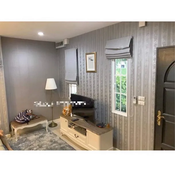 Townhouse for rent in Bang Kapi, Bangkok - Cozy living area with TV console, window shades and accent wallpaper.