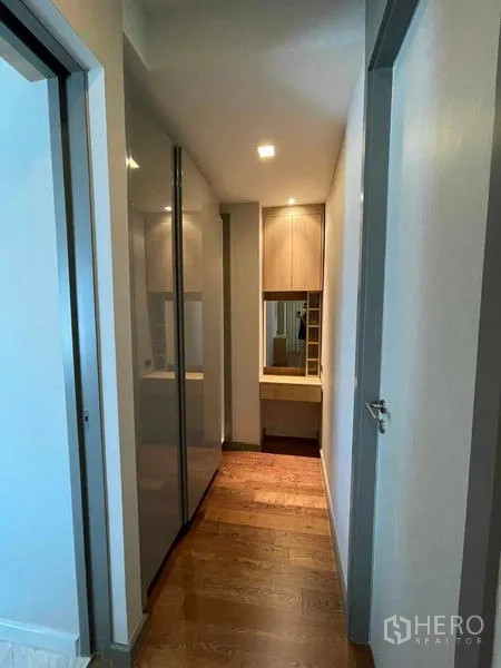 Condominium for rent or sale in Bang Rak, Bangkok - Corridor with wardrobes leading to a vanity and dressing nook.