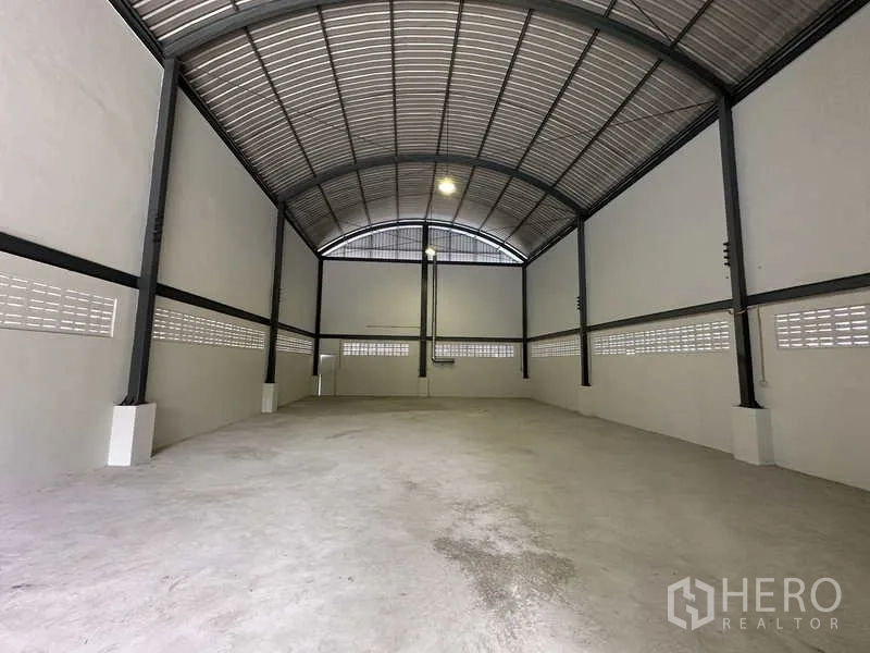 Warehouse for rent in Pak Kret, Nonthaburi - Clear-span warehouse interior with arched steel roof and ventilated block walls.