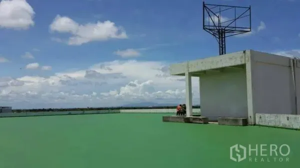 Factory for rent or sale in Khlong Toei, Bangkok - Spacious rooftop deck with green surface and open sky, ideal for utility setup.