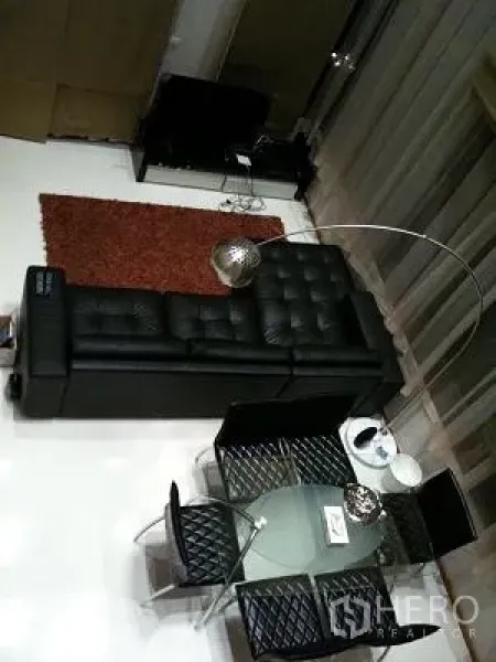 Condominium for rent or sale in Khlong Toei, Bangkok - Overhead view of open-plan living and dining with a glass table, modern sofa, and rug.