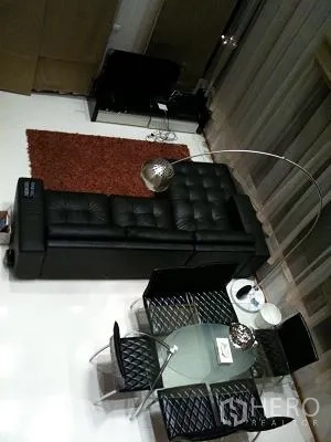 Condominium for rent or sale in Khlong Toei, Bangkok - Overhead view of open-plan living and dining with a glass table, modern sofa, and rug.