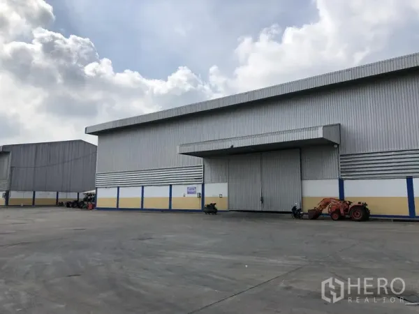 Warehouse for rent in Phra Nakhon Si Ayutthaya - Front of a large warehouse with sliding door and canopy, offering ample truck maneuvering space.