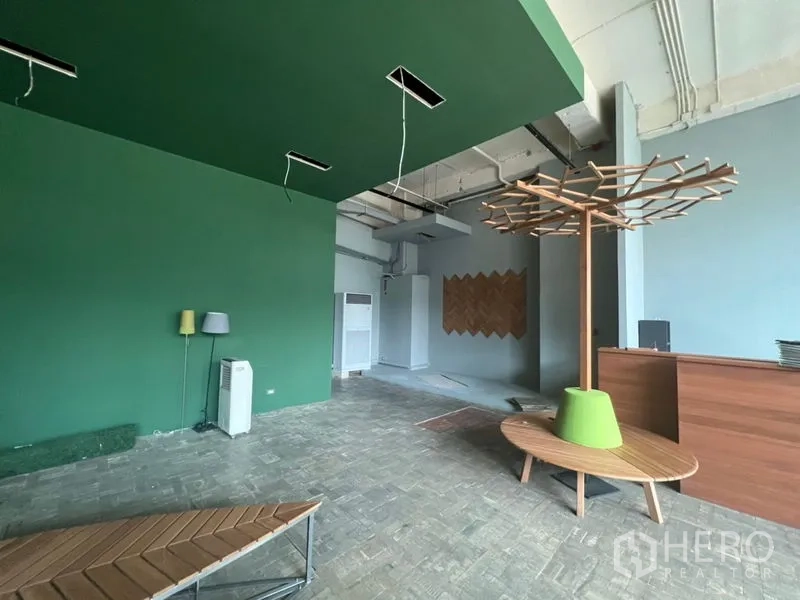 零售空间 出租在Khlong Toei, Bangkok - 零售大厅绿墙、木质接待台与树形展示装置。
