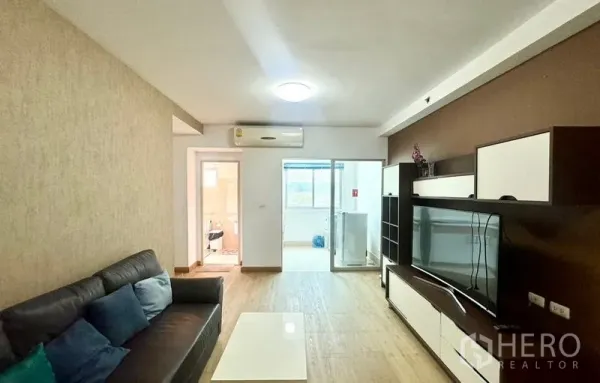 公寓 出租在Huai Khwang, Bangkok - 客厅带内置电视柜，推拉玻璃门通往阳台和洗衣区。