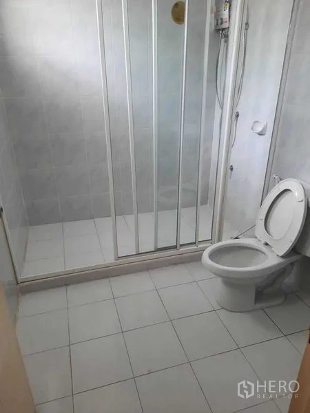 带办公室的家 出租在Watthana, Bangkok - 洁净浴室，玻璃淋浴间、白色瓷砖与坐便器。