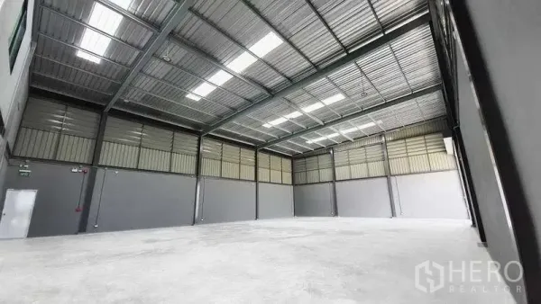 Factory for rent or sale in Bang Bo, Samut Prakan - Spacious warehouse interior with high clear-span steel roof, skylights and polished concrete floor suitable for trucks and racking.