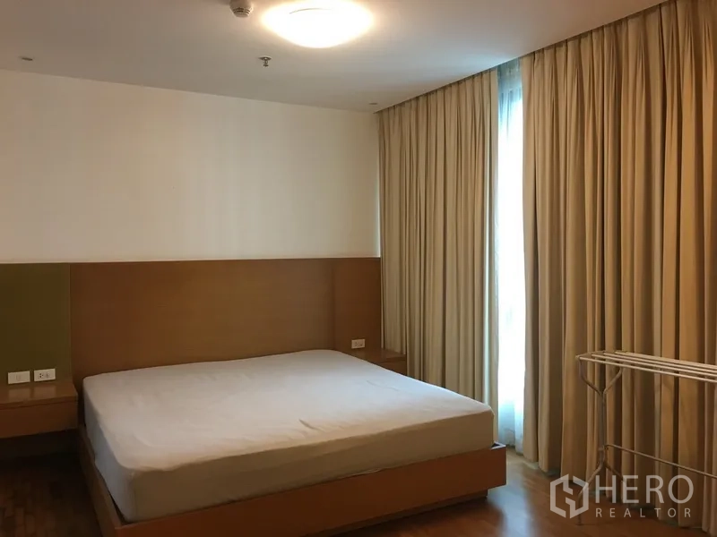 คอนโด ให้เช่าในPathum Wan, Bangkok - ห้องนอนใหญ่เตียงคิงส์ไซส์ ผ้าม่านเต็มสูง แสงอบอุ่น และพื้นไม้