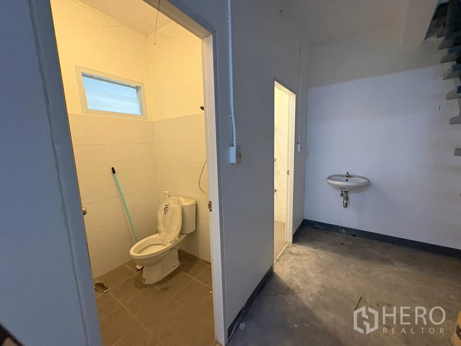 Warehouse for rent in Bang Na, Bangkok - Restroom area with toilet and sink inside the warehouse.