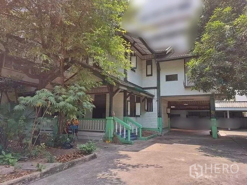 บ้าน ให้เช่าในBang Rak, Bangkok - ด้านหน้าบ้านไม้สองชั้น พร้อมลานจอดรถ ระเบียง และต้นไม้ร่มรื่น.