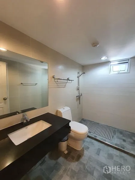 คอนโด ให้เช่าในHuai Khwang, Bangkok - ห้องน้ำสไตล์โมเดิร์น มีอ่างล้างหน้า กระจกบานใหญ่ โถสุขภัณฑ์ และโซนอาบน้ำแบบวอล์กอิน มีช่องแสง