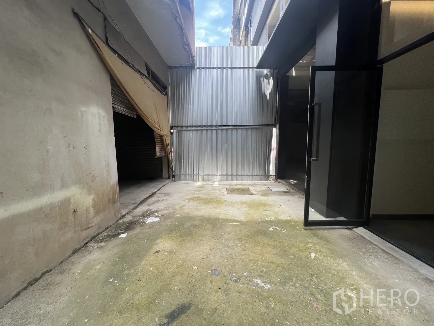 ตึกแถว for rent in Bang Rak, Bangkok - ลานทางเข้ามีกำแพงและประตูกระจกข้างผนังดิบ