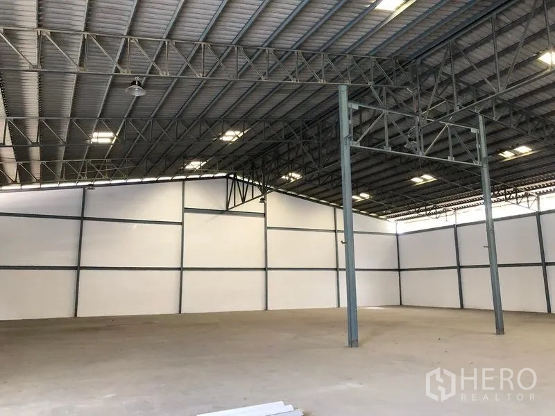 Warehouse for rent in Khlong Luang, Pathum Thani - Spacious warehouse interior with high steel truss roof, bright lighting and smooth concrete floor.